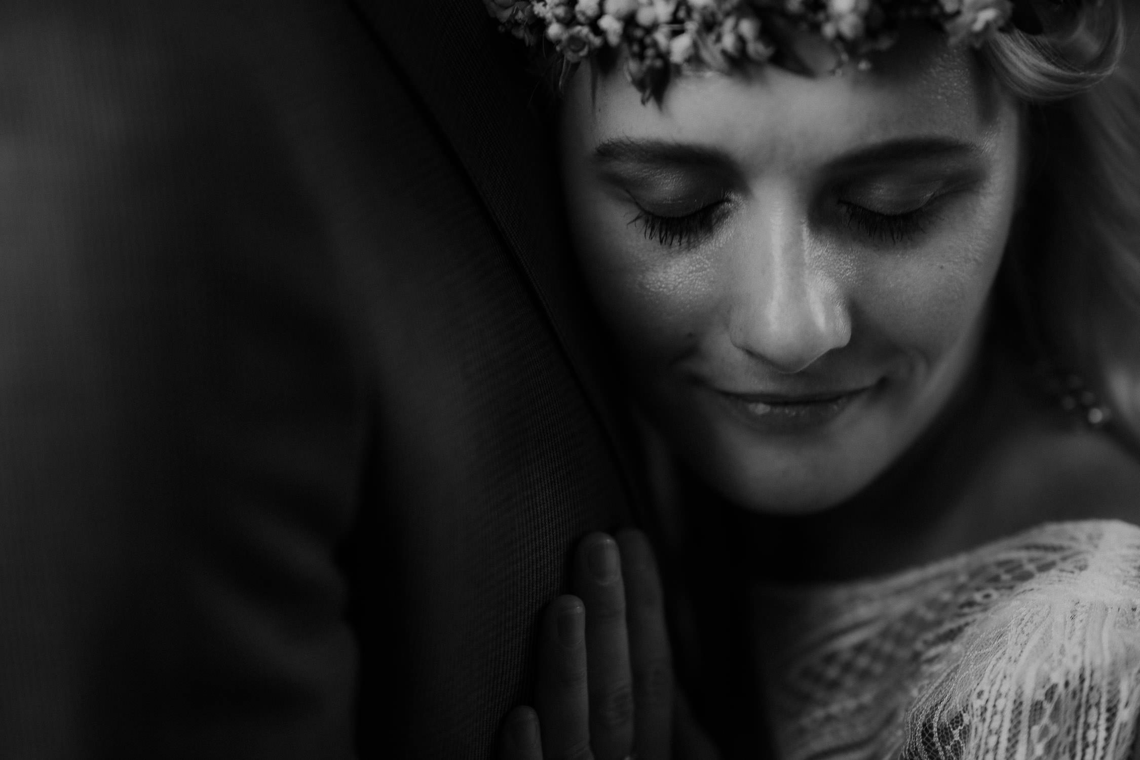 Portrait des Brautpaares in Schwarz Weiß. Fotografiert von Hochzeitsfotograf Axel Link. Die Braut schmiegt sich an den Bräutigam.