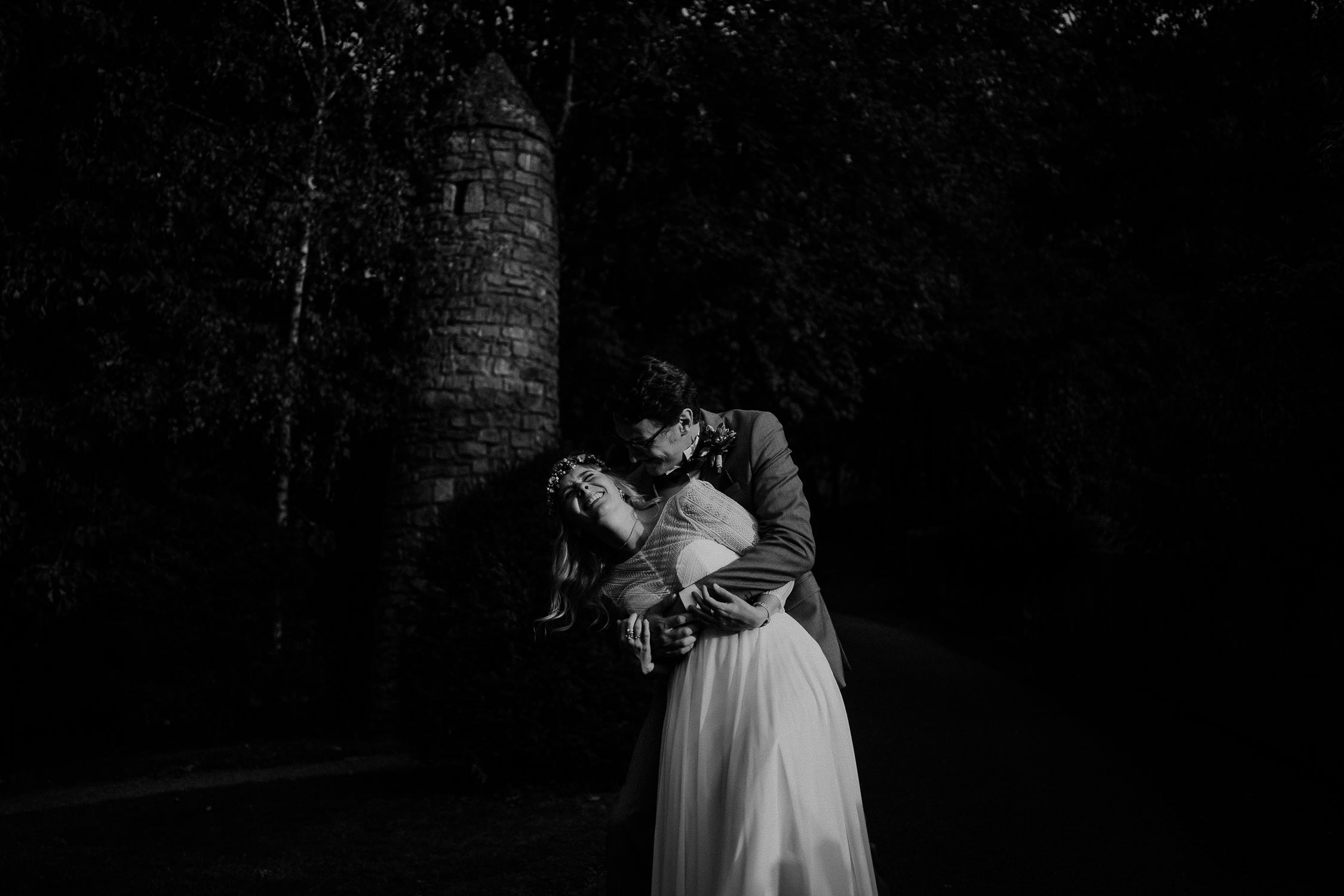 Portrait des Brautpaares in Schwarz Weiß. Fotografiert von Hochzeitsfotograf Axel Link. Die Braut lacht.