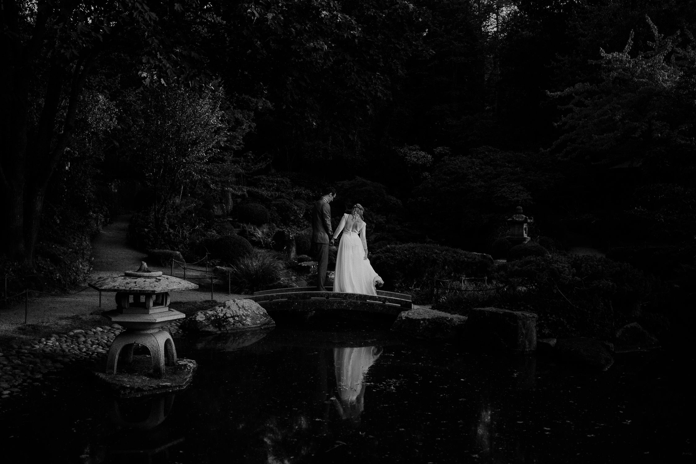 Portrait des Brautpaares in Schwarz Weiß. Fotografiert von Hochzeitsfotograf Axel Link. Das Brautpaar spiegelt sich im See.