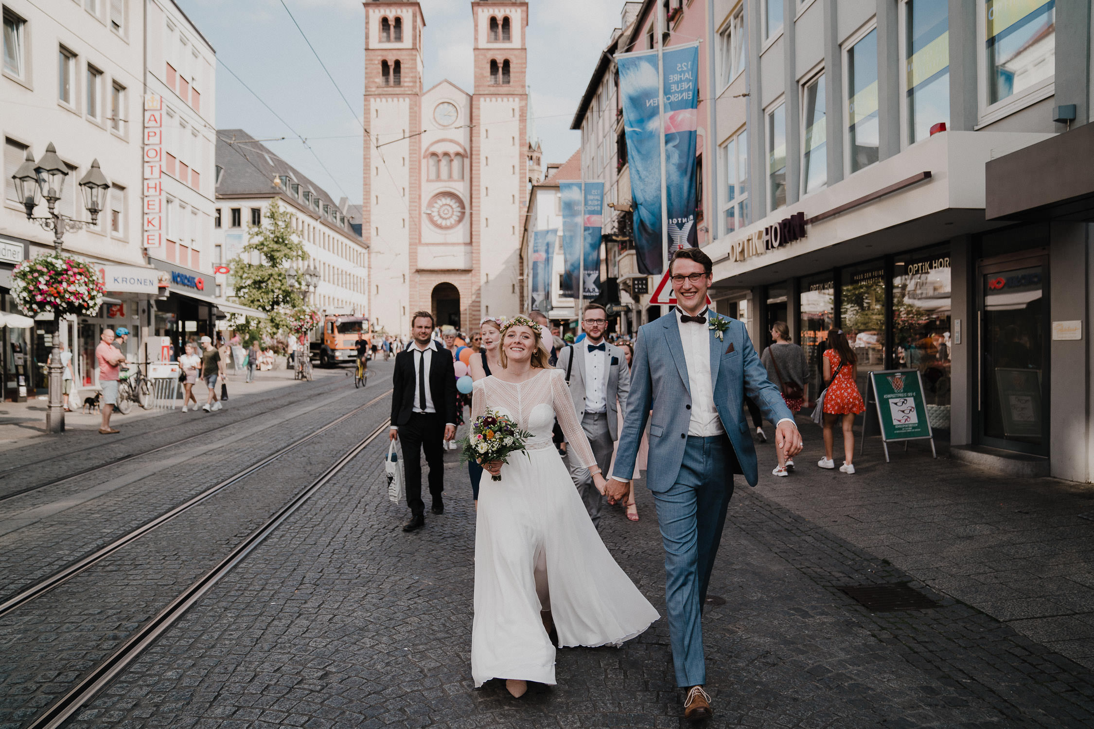 Das Brautpaar läuft in der Domstraße Wuerzburg. Fotografiert von Hochzeitsfotograf Axel Link