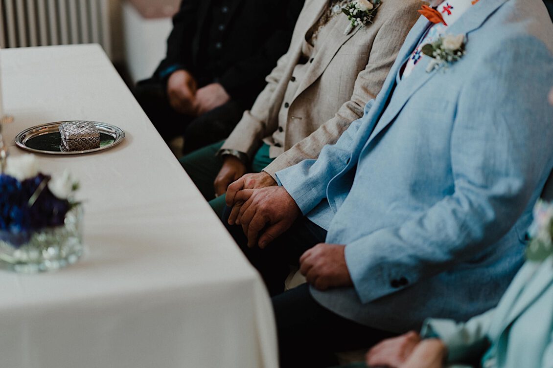 05_Hochzeitsfotograf-Wuerzburg-3_Schwules Hochzeitspaar ha?lt sich an den Ha?nden wa?hrend der Trauung.