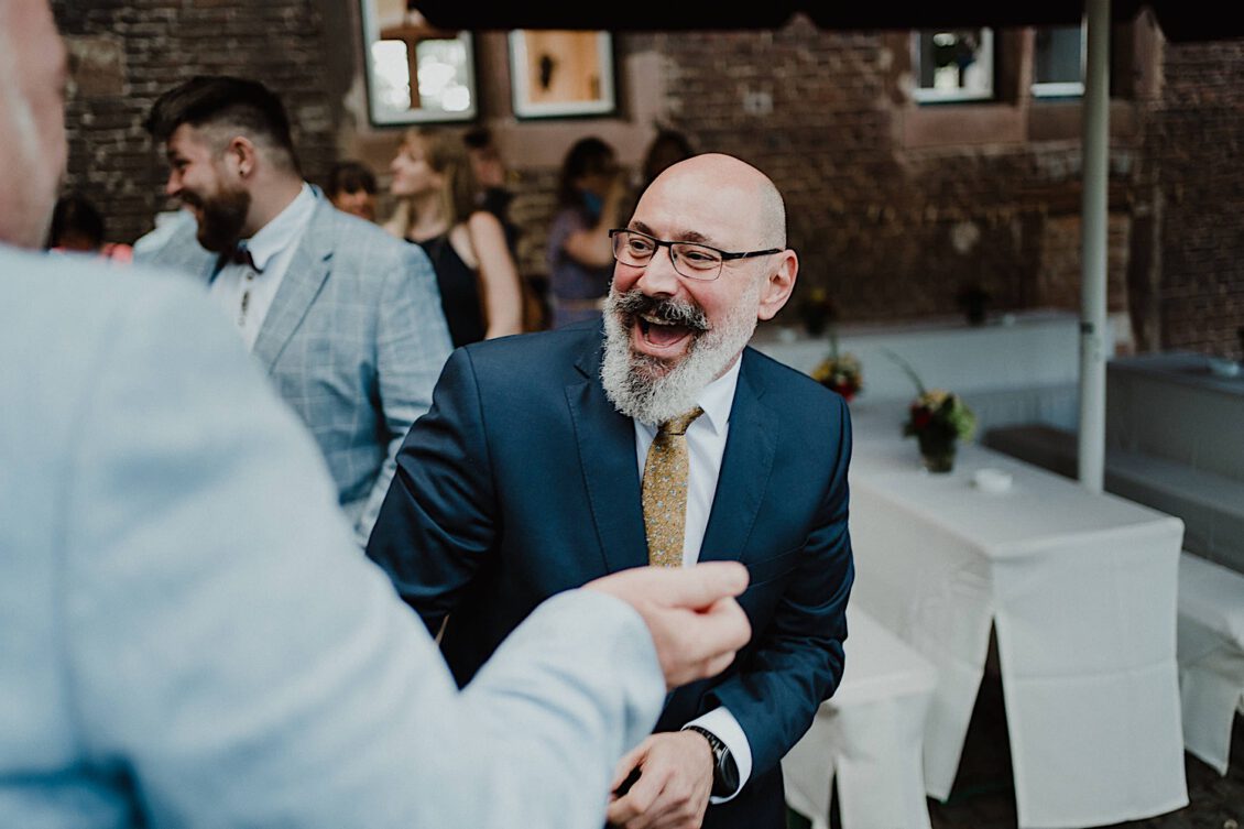 15_Hochzeitsfotograf-Wuerzburg-14_Ga?ste gratulieren dem Hochzeitspaar nach der Trauung bei der schwulen Hochzeit in der Burg Konradsheim bei Ko?n. Hochzeitsbild vom Hochzeitsfotograf Axel Link