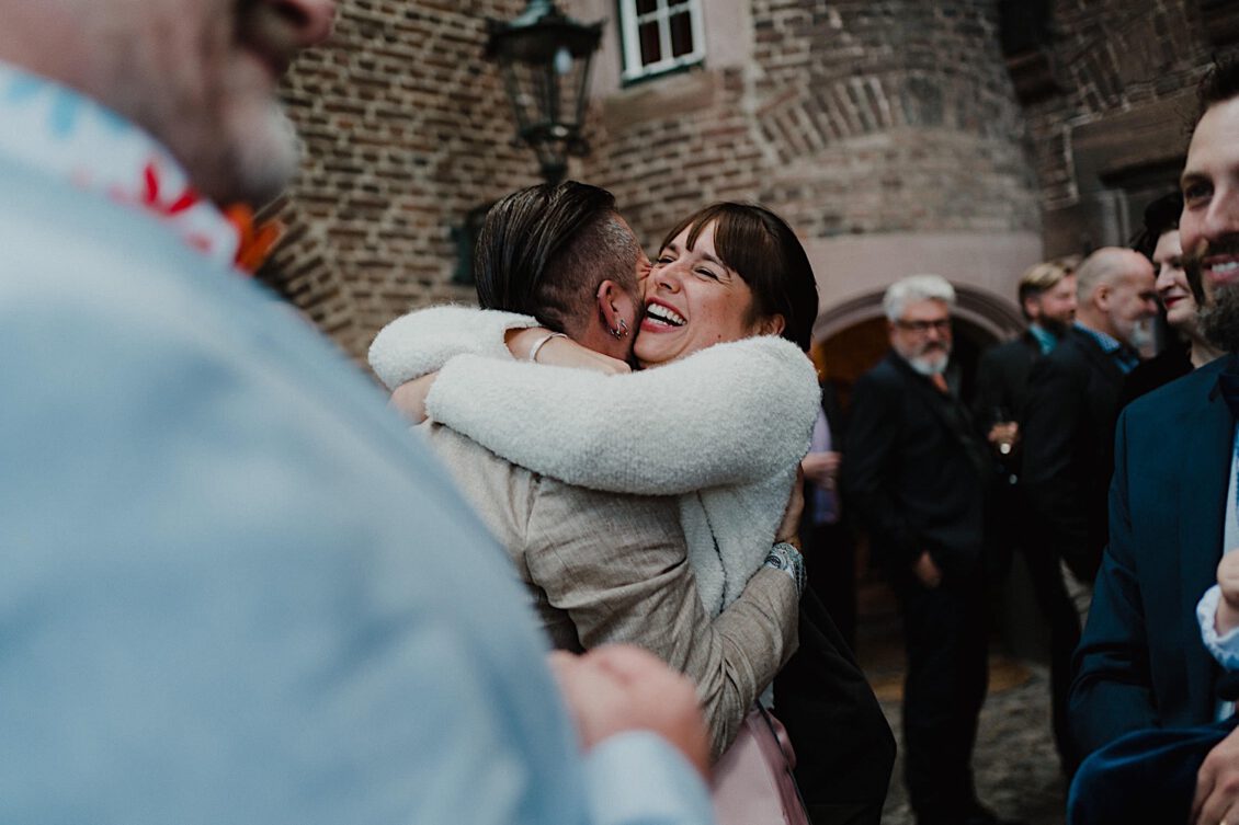 16_Hochzeitsfotograf-Wuerzburg-16_Ga?ste gratulieren dem Hochzeitspaar nach der Trauung bei der schwulen Hochzeit in der Burg Konradsheim bei Ko?n. Hochzeitsbild vom Hochzeitsfotograf Axel Link