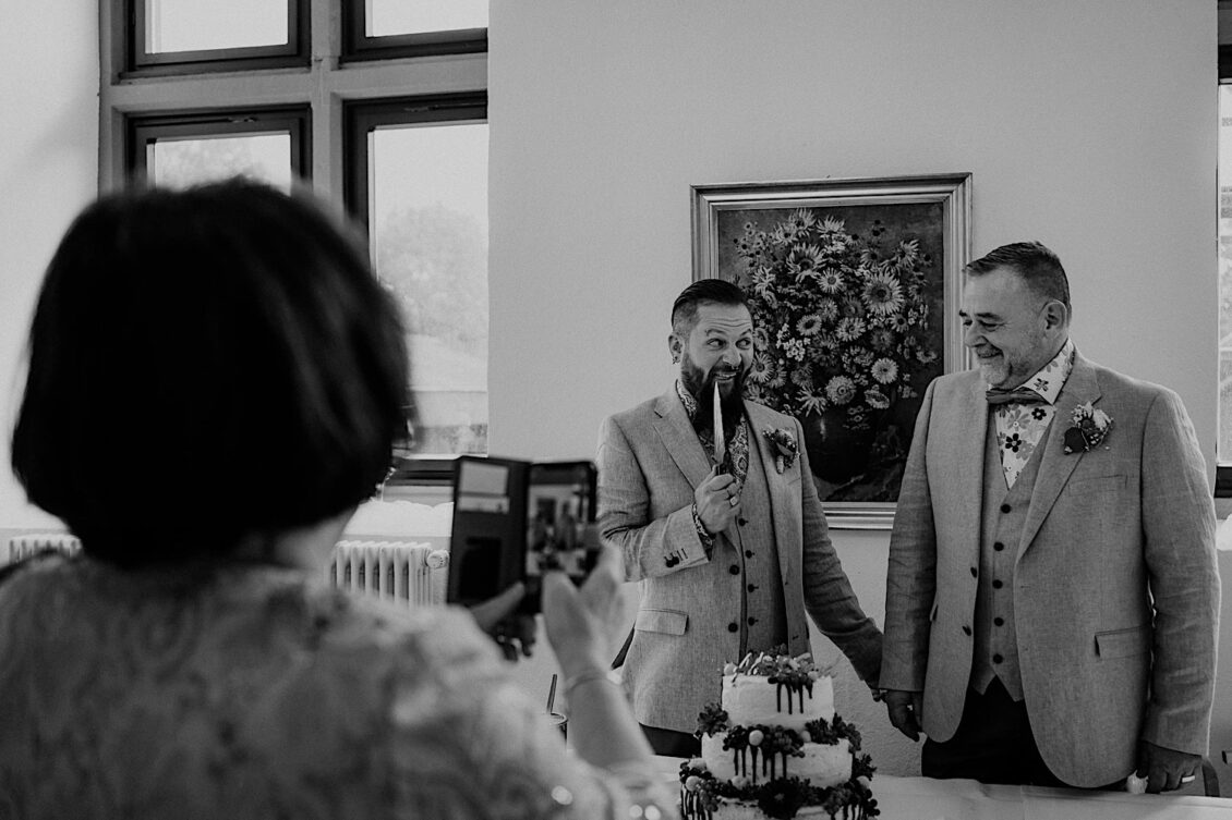 29_Hochzeitsfotograf-Wuerzburg-23_Das Hochzeitspaar schneidet die Hochzeitstorte an bei schwulen Hochzeit in der Burg Konradsheim bei Ko?n. Hochzeitsbild vom Hochzeitsfotograf Axel Link